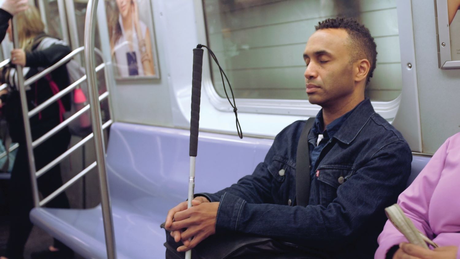 A man sits in a subway train with his eyes closed