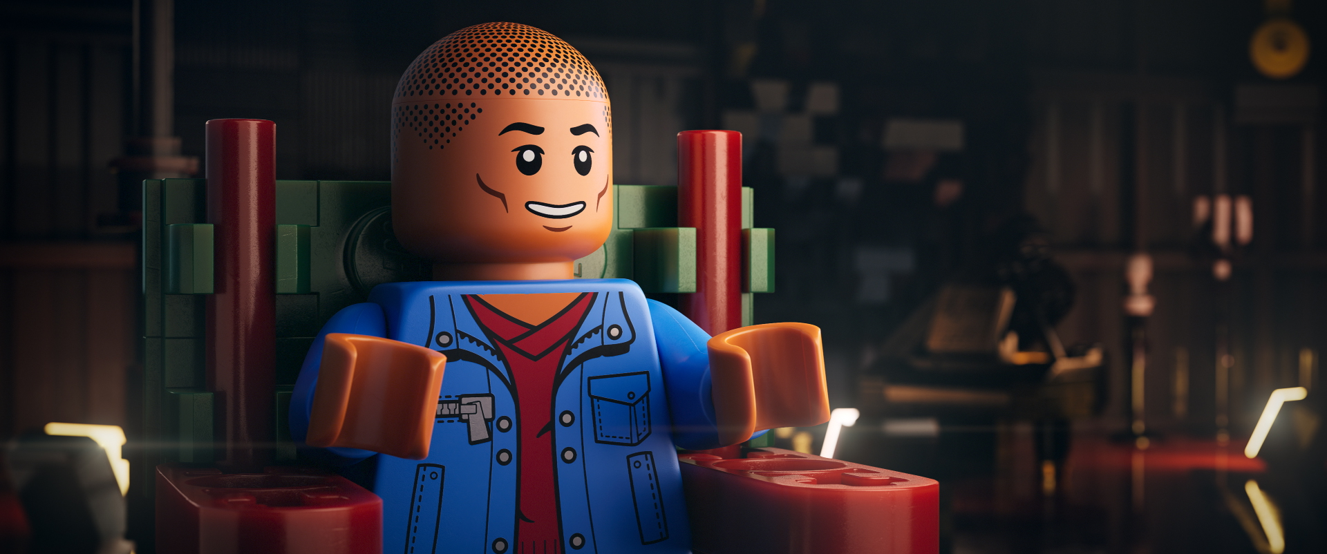 Singer/rapper Pharrell Williams as a LEGO man. He is sitting in a chair wearing a blue jacket with a red shirt.