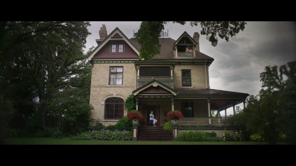The Nest is an old three story manor with beige bricks and a brown roof. The sky is grey and cloudy.