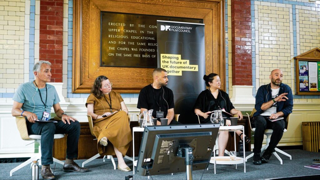 Five people are seated at a table in a panel discussion.