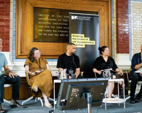 Five people are seated at a table in a panel discussion.