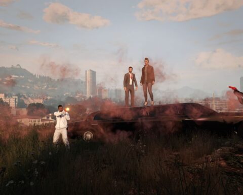 Four players are pictured in the video game Grand Theft Auto. Two stand atop a hill, and then there is a player on either side of them. The players to the sides have their guns drawn.