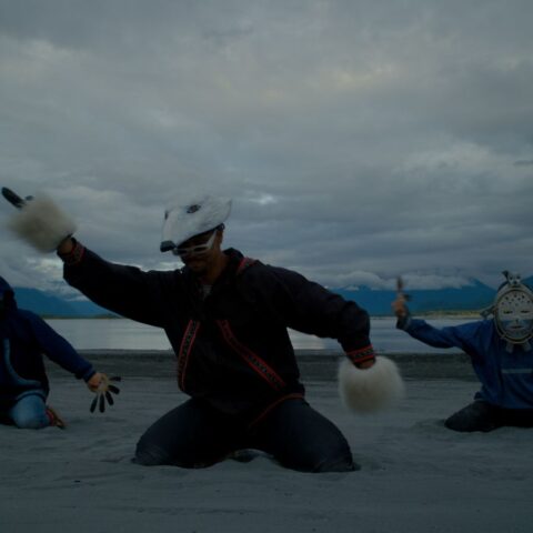 Ossie Kairaiuak (Yup’ik) of the musical group Pamyua dances a mask carved by Yup’ik artist Drew Michael.