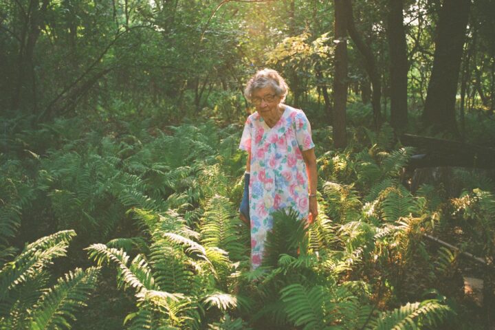 Agatha standing in her garden with a ray of sunlight shining over her and her plants