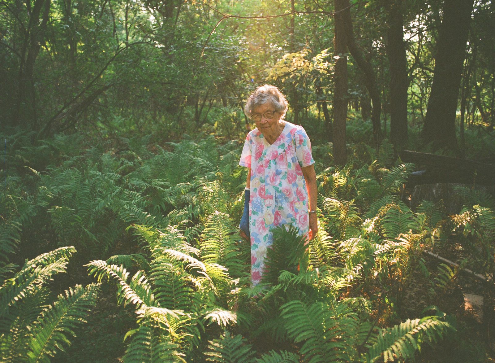 Agatha standing in her garden with a ray of sunlight shining over her and her plants