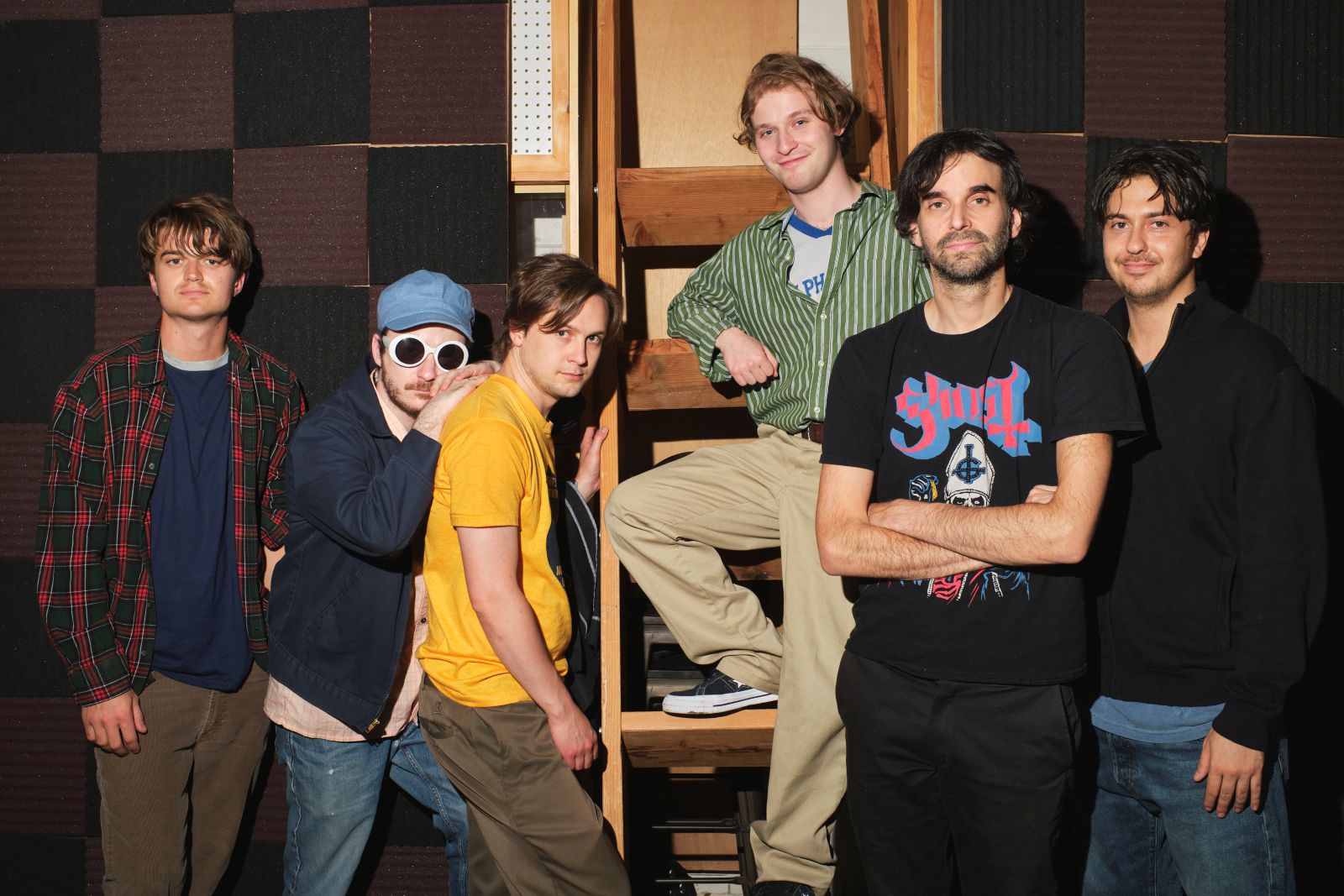 five actors portraying the band Pavement pose with director Alex Ross Perry. They are all wearing 1990s' style t-shirts and dress.