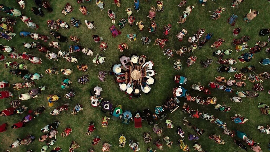 An overhead view of Indigenous people beating a drum and dancing from the Killers of the Flower Moon (2023)