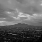 A black and white photo of Mount Vesuvius and the surrounding landscape of Naples, Italy.