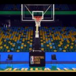 A view of a basketball net in an empty court and stadium.