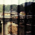 A vintage photograph of a bridge. There are black vertical lines patterning the photo