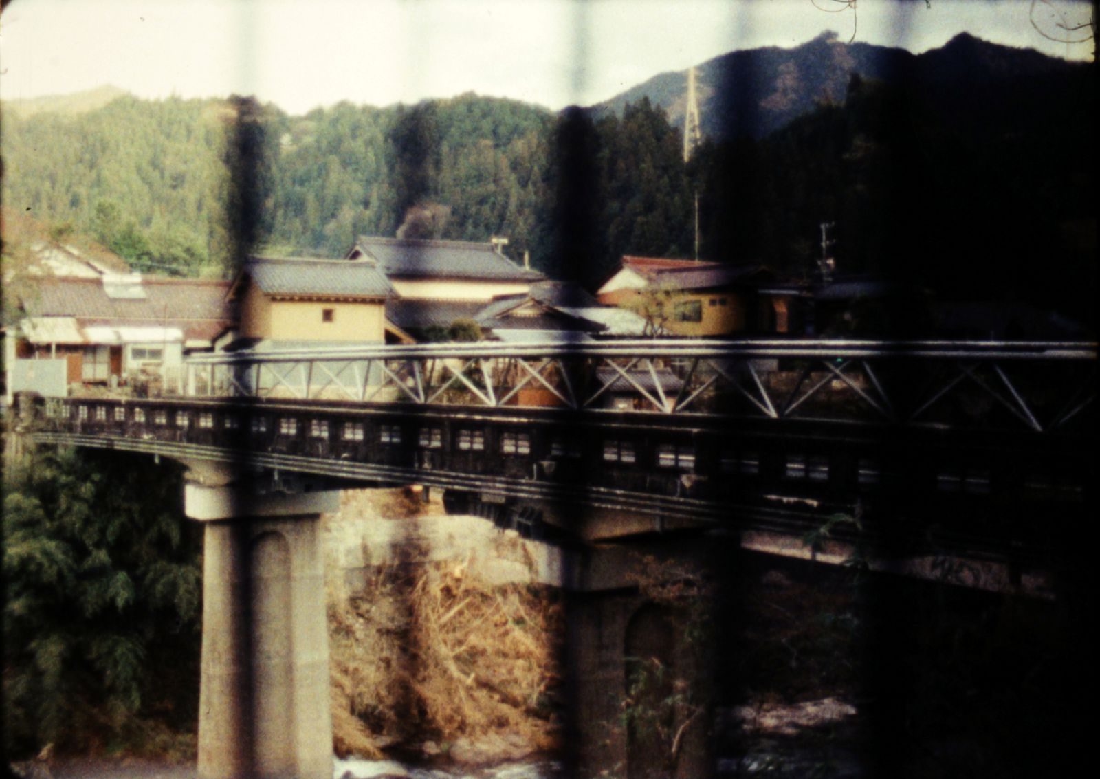 A vintage photograph of a bridge. There are black vertical lines patterning the photo