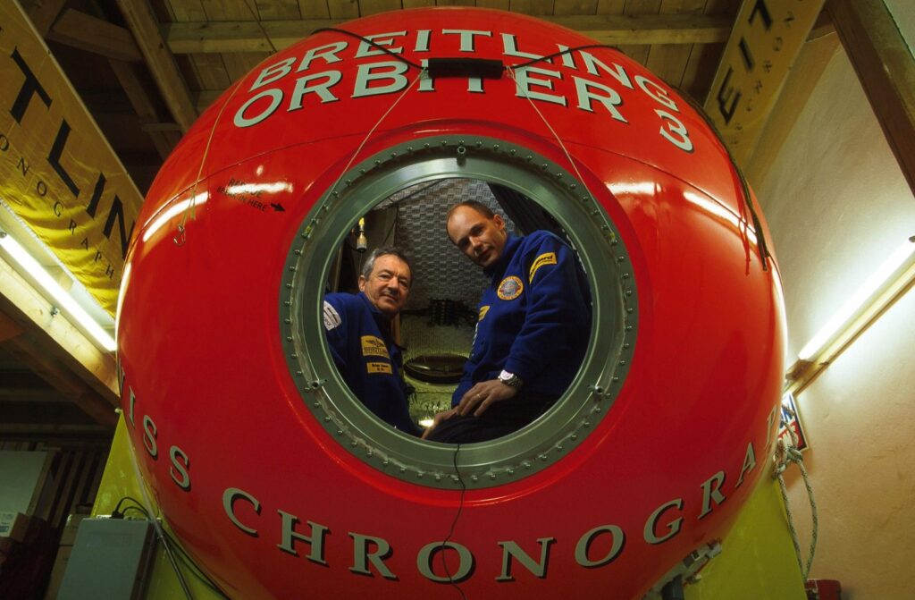 Brian Jones and Bertrand Piccard are pictured in Breitling Orbiter 3, a red sphere that housed their balloon adventure