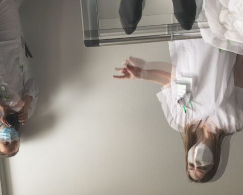 A point of view shot from a patient in a hospital bed, looking at two blurry doctors who are upside down.