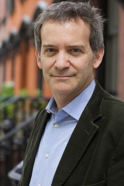 Nick Davis is a white man with grey hair. He is pictured in a dark jacket and light blue collared shirt.