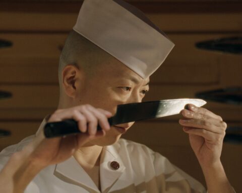Chef Masaki Saito examines the blade on his knife.