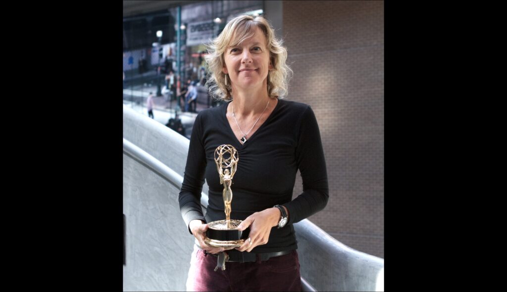 Tracey Friesen holding the Northwest Regional Emmy Award for Best Historical Documentary for the film Mighty Jerome in front of the NFB’s Vancouver studio in September 2012.
