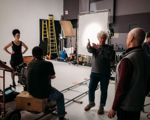 Filmmaker Ron Mann directors a documentary film crew on a sound stage.