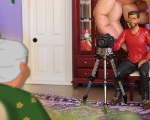 A model of a filmmaker sets up a camera before an animated image of his grandmother.