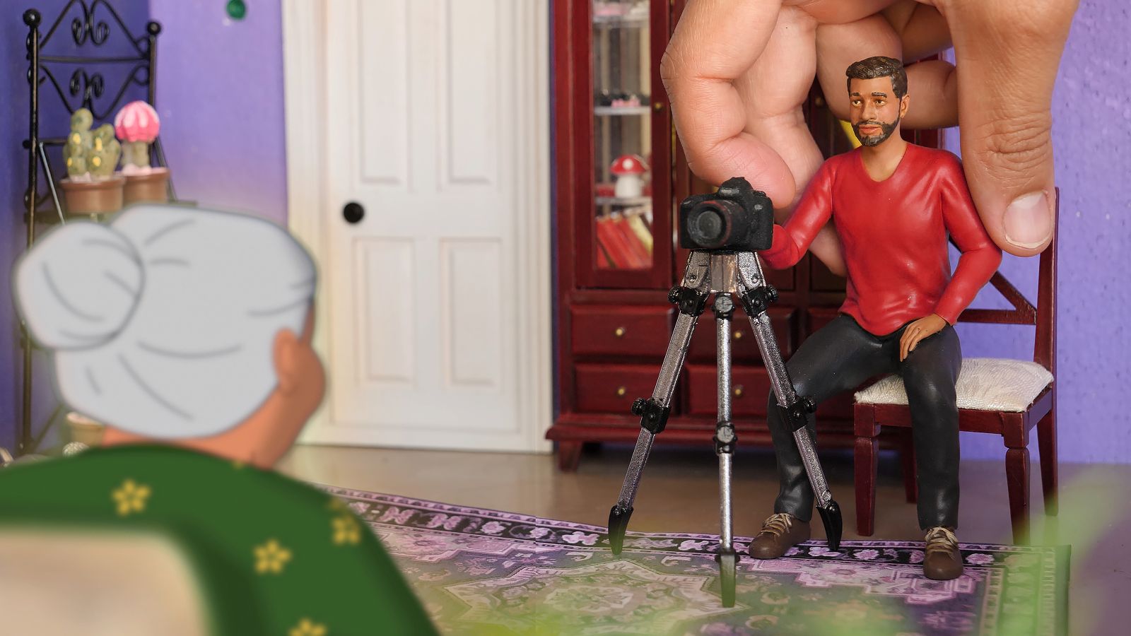 A model of a filmmaker sets up a camera before an animated image of his grandmother.