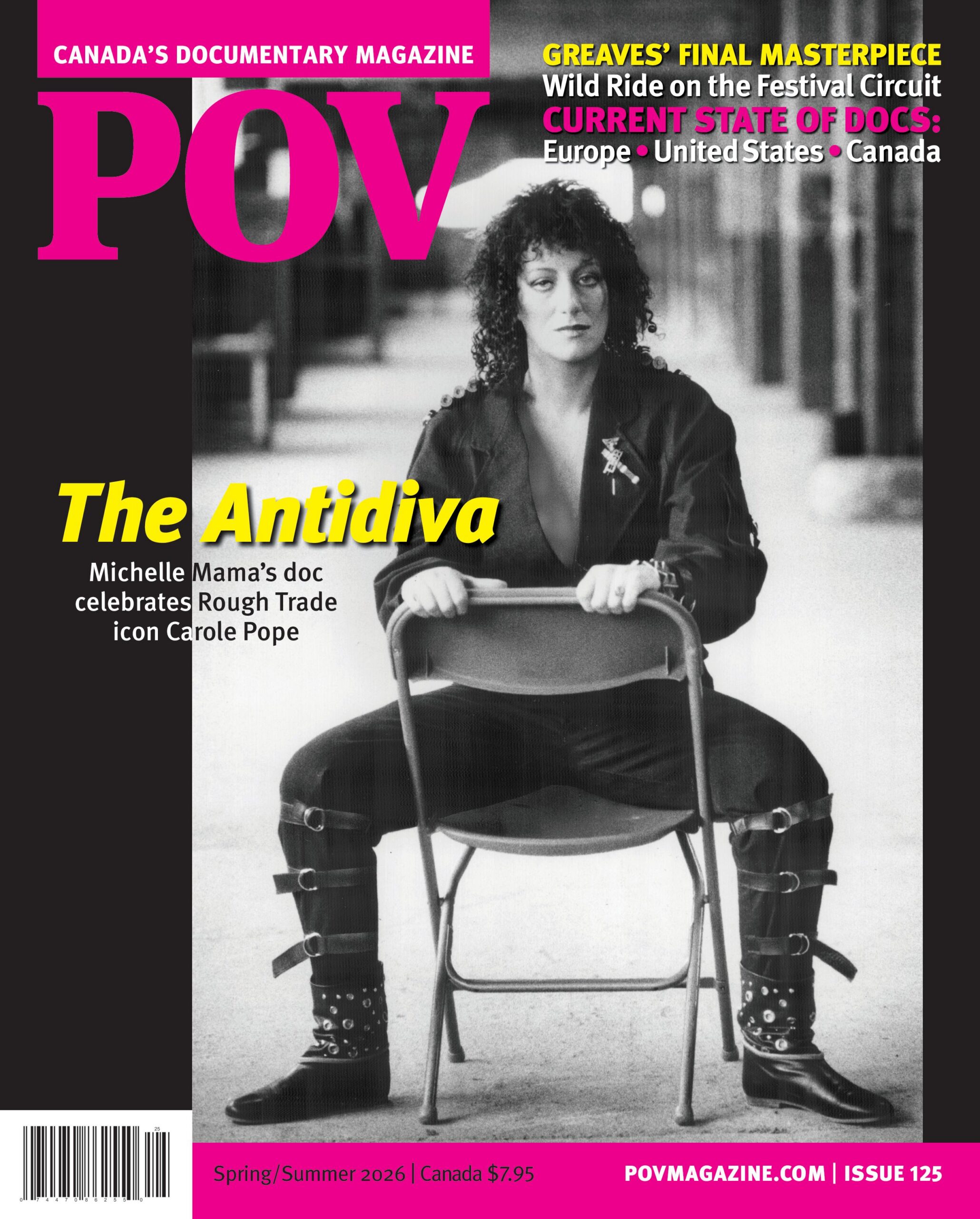 An archival image of rocker Carole Pope seated in a backwards folding chair. She is wearing a black leather jumpsuit and boots. This is a cover for POV issue #125 with the letters POV in bright pink and the subtitle The Antidiva in yellow.