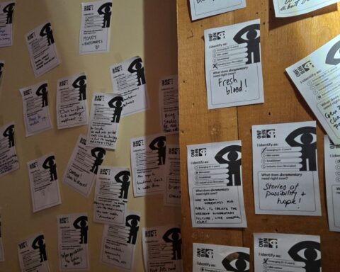 A series of white pieces of paper taped to a wall. They have the NFB logo in the top right corner and various messages scribbled in black marker.