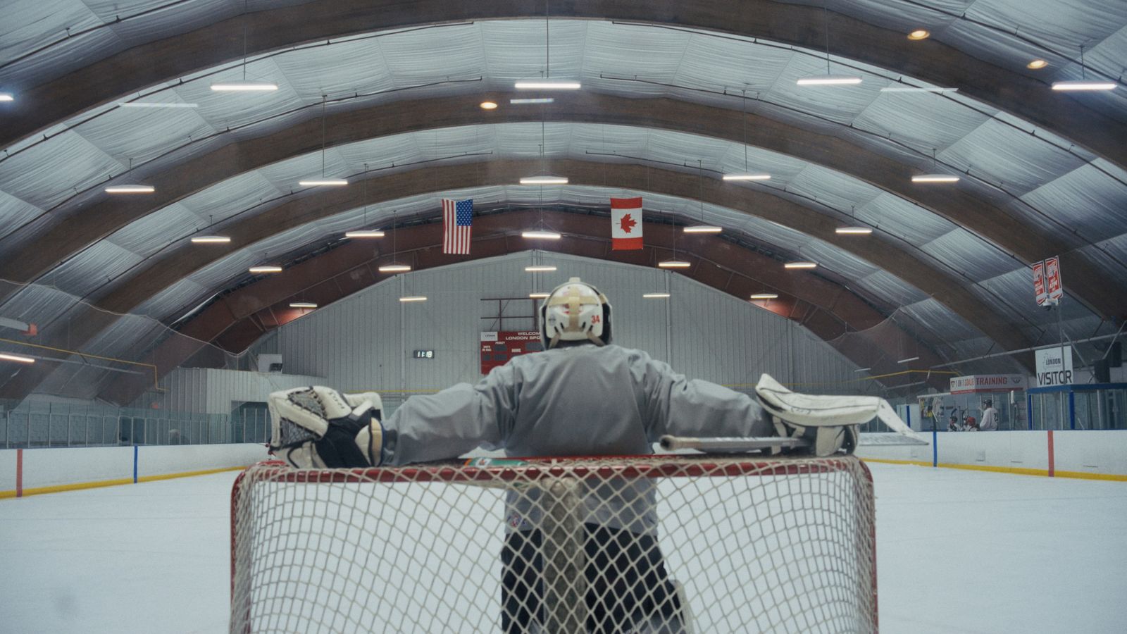 A lone goalie waits for teammates to take the ice during a pickup game in London, Ontario.
