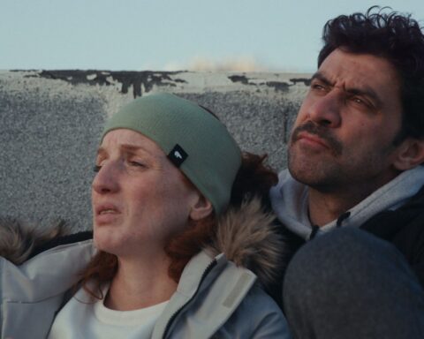 A Palestinian husband and wife lean in close together while looking up towards the sky.