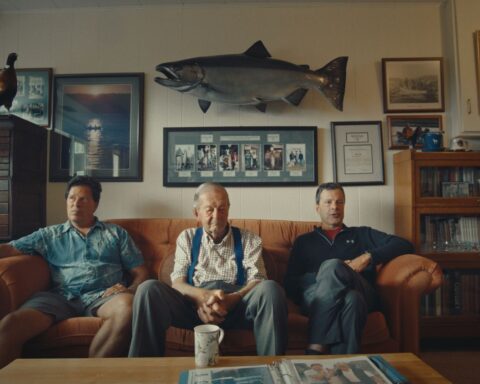 Richard, Mike, and Roger Gage at the Gage family home. Mike’s 61.5-pound Tyee hangs on the wall above them