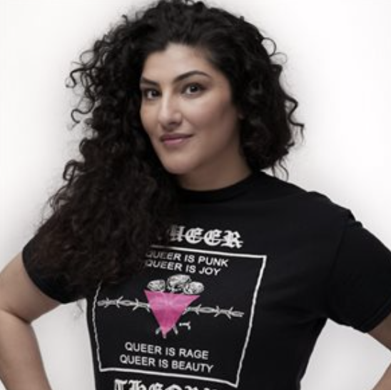 Filmmaer Michelle Mama wears a black t-shirt with a pink ACT-UP triangle, with the word QUEER in white letters at the top.
