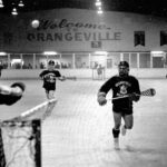 A black and white photo of a lacrosse game in action.