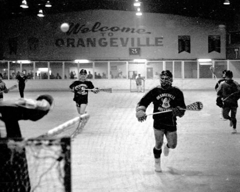 A black and white photo of a lacrosse game in action.