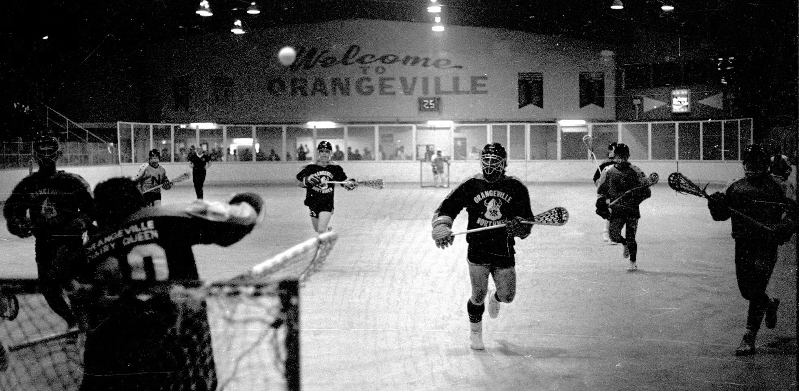 A black and white photo of a lacrosse game in action.