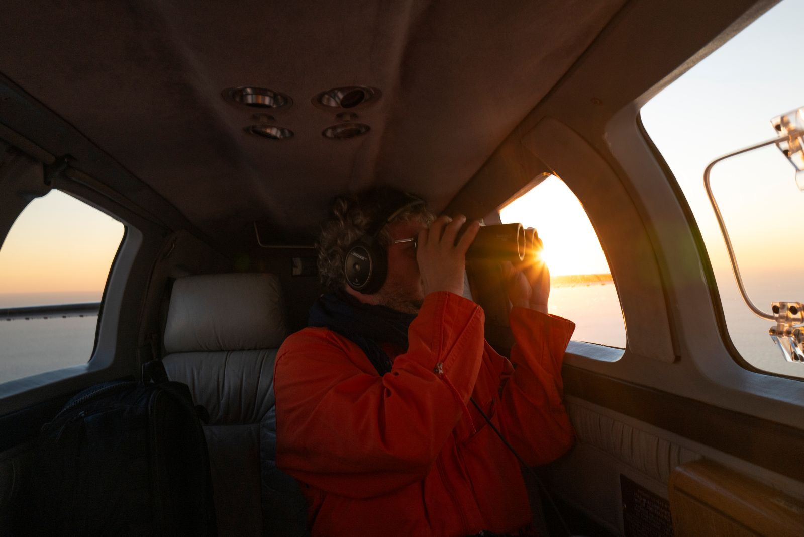 Sea-Watch volunteer Matthias looks through binoculars spotting for migrant boats on board the SeaBird 2.