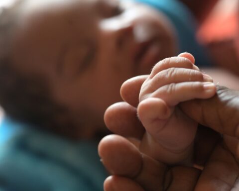 A tender moment between a newborn and Maria Reyes, our Colombian midwife from Buenaventura, during a postpartum checkup in the barrios.