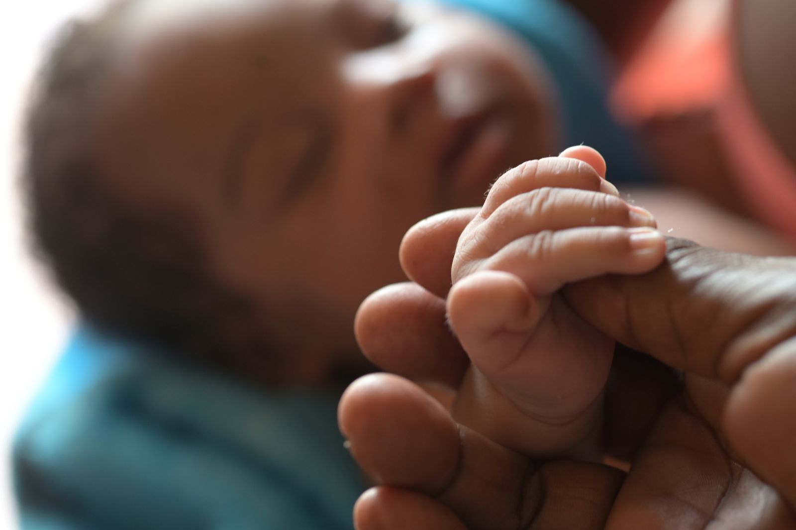 A tender moment between a newborn and Maria Reyes, our Colombian midwife from Buenaventura, during a postpartum checkup in the barrios.
