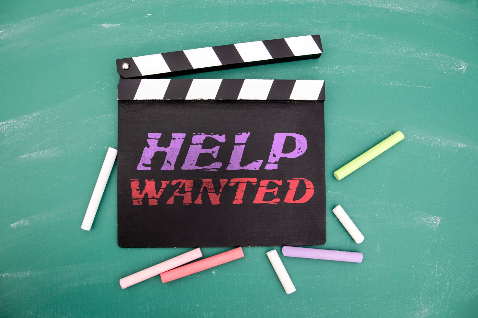 Help Wanted Message on Movie Clapperboard with Chalk on Green Blackboard Background stock photo