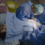a GROUP OF DOCTORS PERFORMS A SURGERY