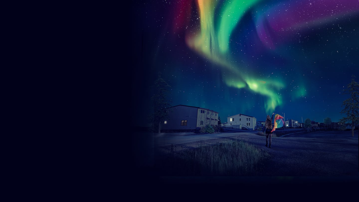 A nighttime image shows the northern lights with ripple through the sky like a Pride flag