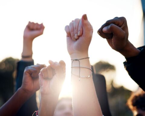 Hands, fist and students with protest outdoor for education riot, university equality and change law. Group, people and power with call to action for free learning, society support and racism justice stock photo