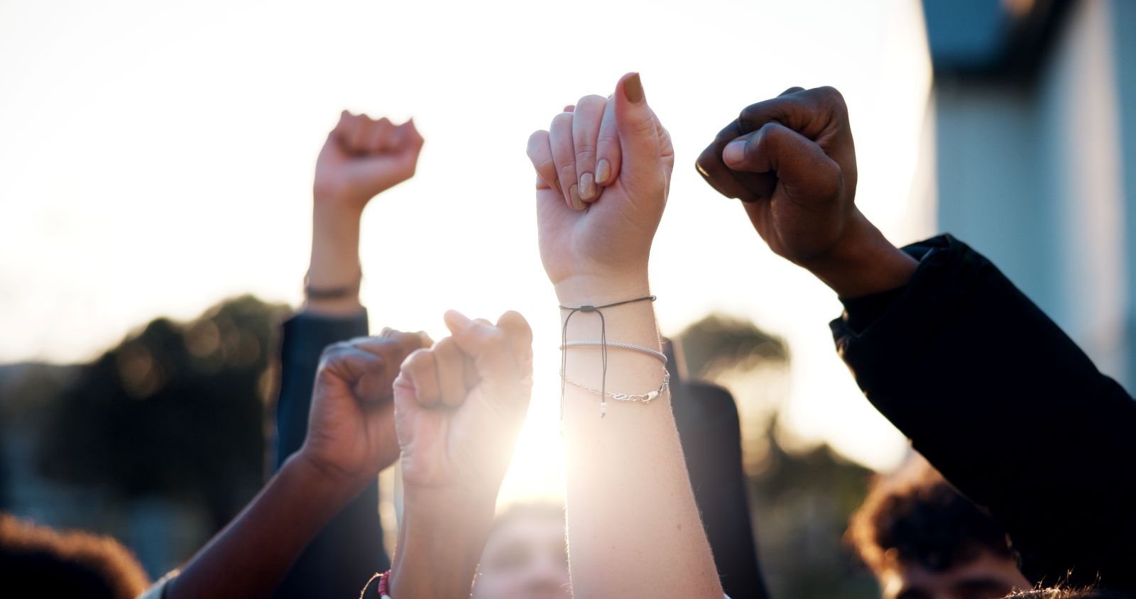 Hands, fist and students with protest outdoor for education riot, university equality and change law. Group, people and power with call to action for free learning, society support and racism justice stock photo