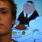 The face of a white man with an early 2000s' hairstyle is pictured beside a fuzzy TV screen showing a scene from Family Guy, where an overweight man in a suit sits at a table with a white dog.