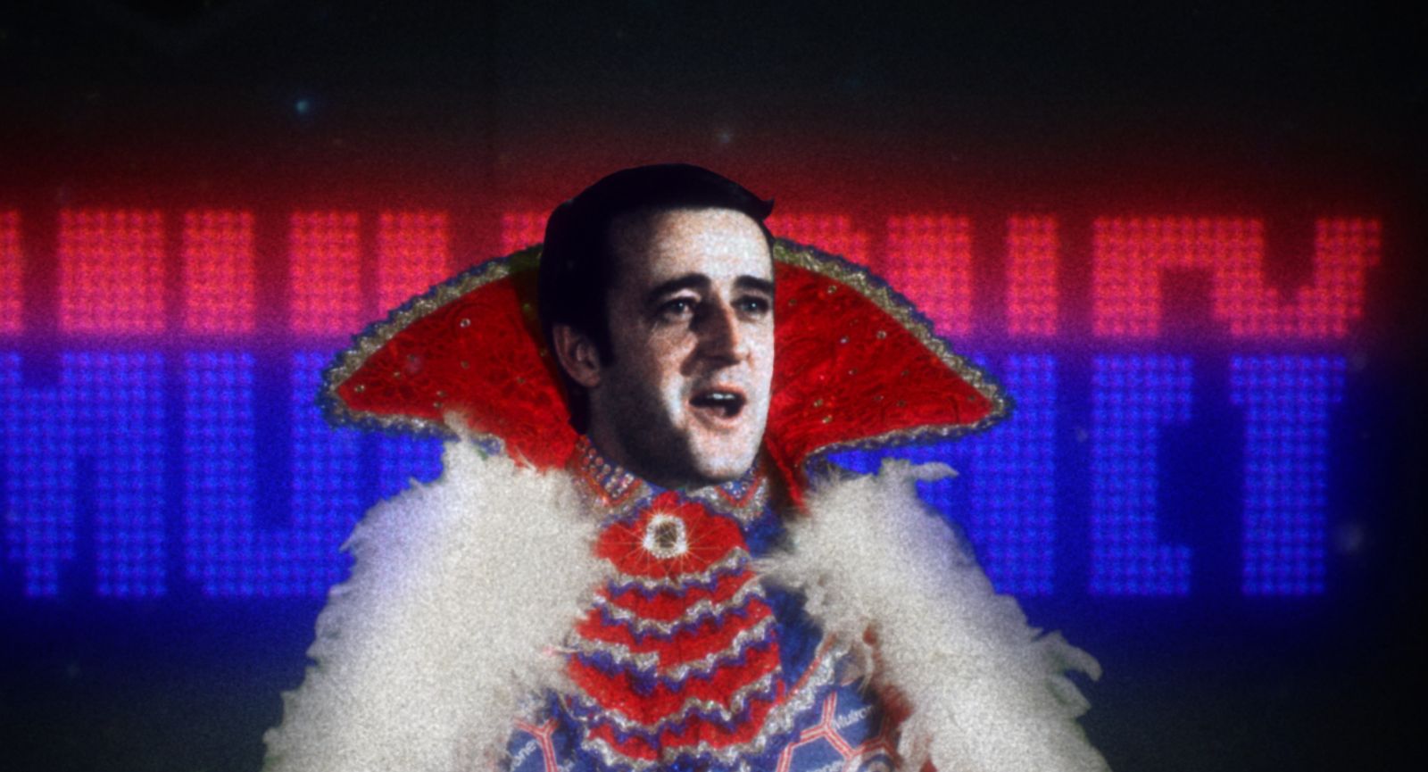 Prime Minister Brian Mulroney appears in a flamboyant Liberace-style outfit with a high collar and white furry trim. The name Mulroney appears behind him in red and blue lights.
