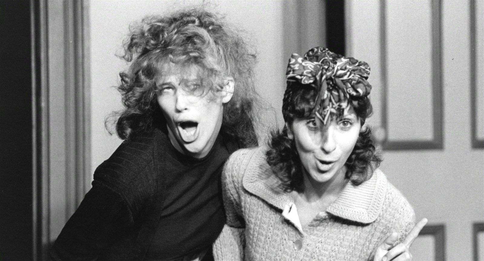 A black and white photo shows young comedians Catherine O'Hara and Andrea Martin making funny faces and being goody during a sketch for SCTV.